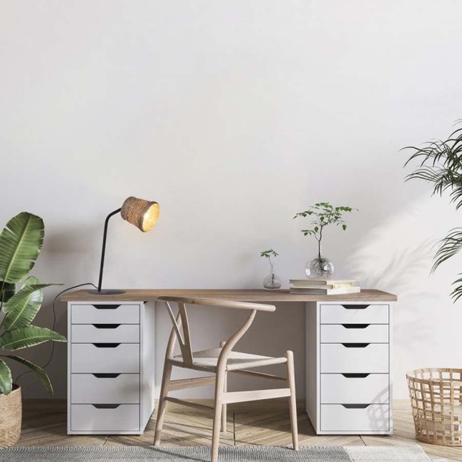Lampe à poser Nude placée sur un bureau avec des plantes, un meuble blanc et un décor épuré.Dakar-Sénègal