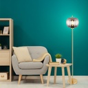 Lampadaire Blacky en métal laiton et verre fumé placé dans un salon moderne, avec un fauteuil et une étagère à Dakar, Sénégal