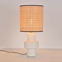 Lampe à poser Venus en céramique blanche avec abat-jour en fibre naturelle allumé, éclairant l'espace. Dakar, Sénégal