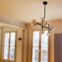 Lustre 10 lampes titan en métal noir et verre opaque exposé dans un salon.Dakar, Sénégal