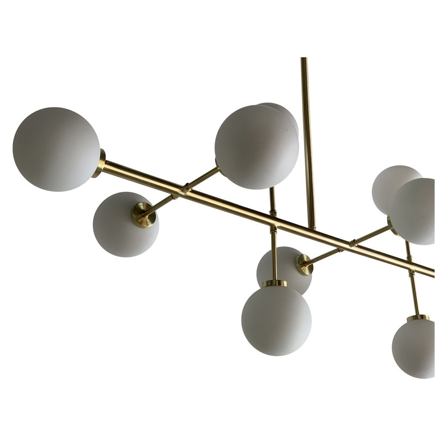 Vue latérale du lustre Titan à 10 lampes, structure en métal laiton et verre opaque, Dakar, Sénégal