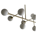 Vue latérale du lustre Titan à 10 lampes, structure en métal laiton et verre opaque, Dakar, Sénégal