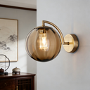 Applique murale avec tige dorée et boule en verre ambré