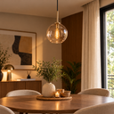 Salle à manger chaleureuse, suspension noire et table décorée.png